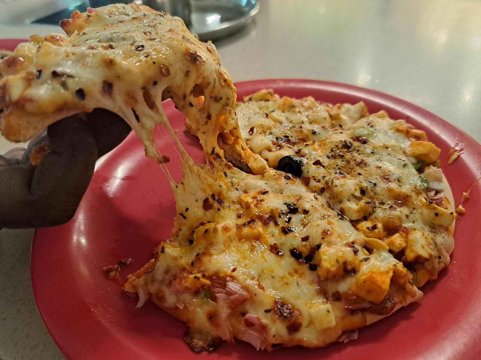 Slice lifted from a pizza with a long stretchy cheese pull