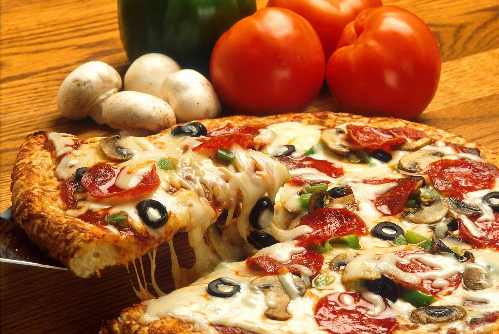 Loaded specialty slice being lifted with a cheese pull